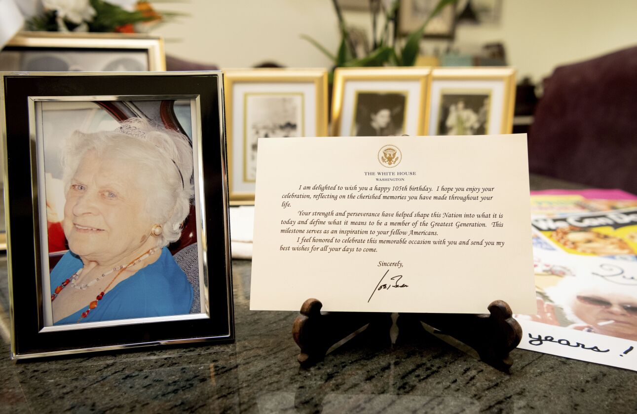 A note from President Joe Biden is seen placed among photos of Primetta Giacopini, who died of COVID-19 at the age of 105.